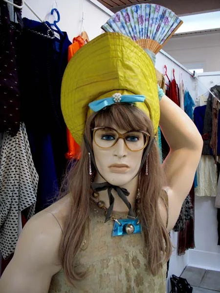 Mannequin med gul hovedbeklædning og malet ansigt.